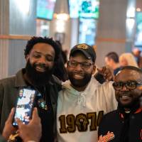 Event attendee taking photo of three other guests with his phone